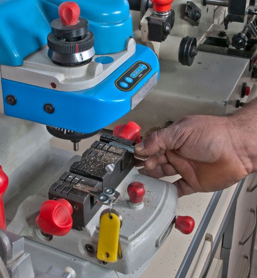 Close-up of a locksmith using a key-cutting machine