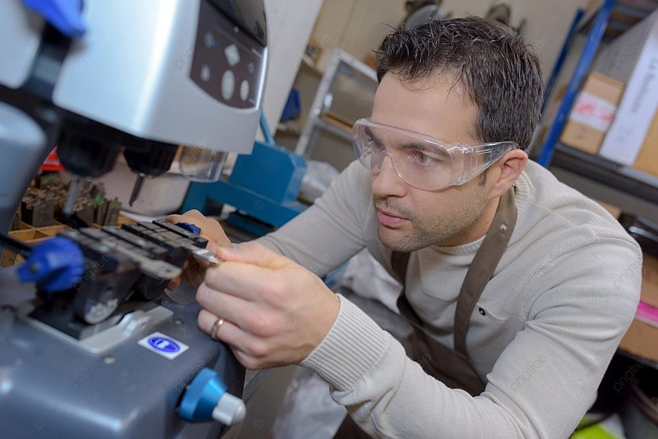 Close-up of a locksmith using a key-cutting machine